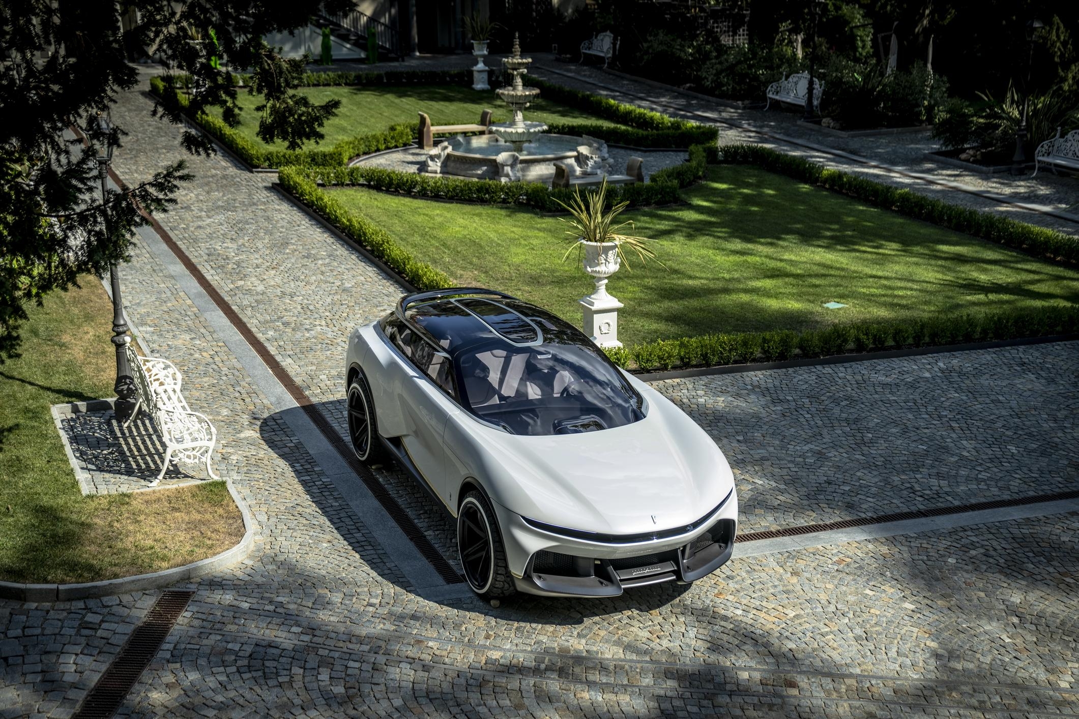 futuristic car sits in a shadowy green garden